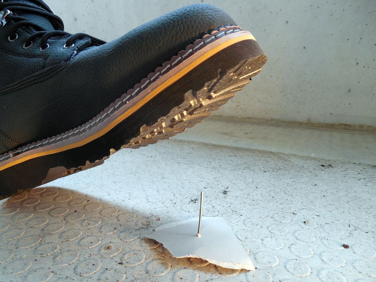 critical vs minor workplace injury. person stepping on nail