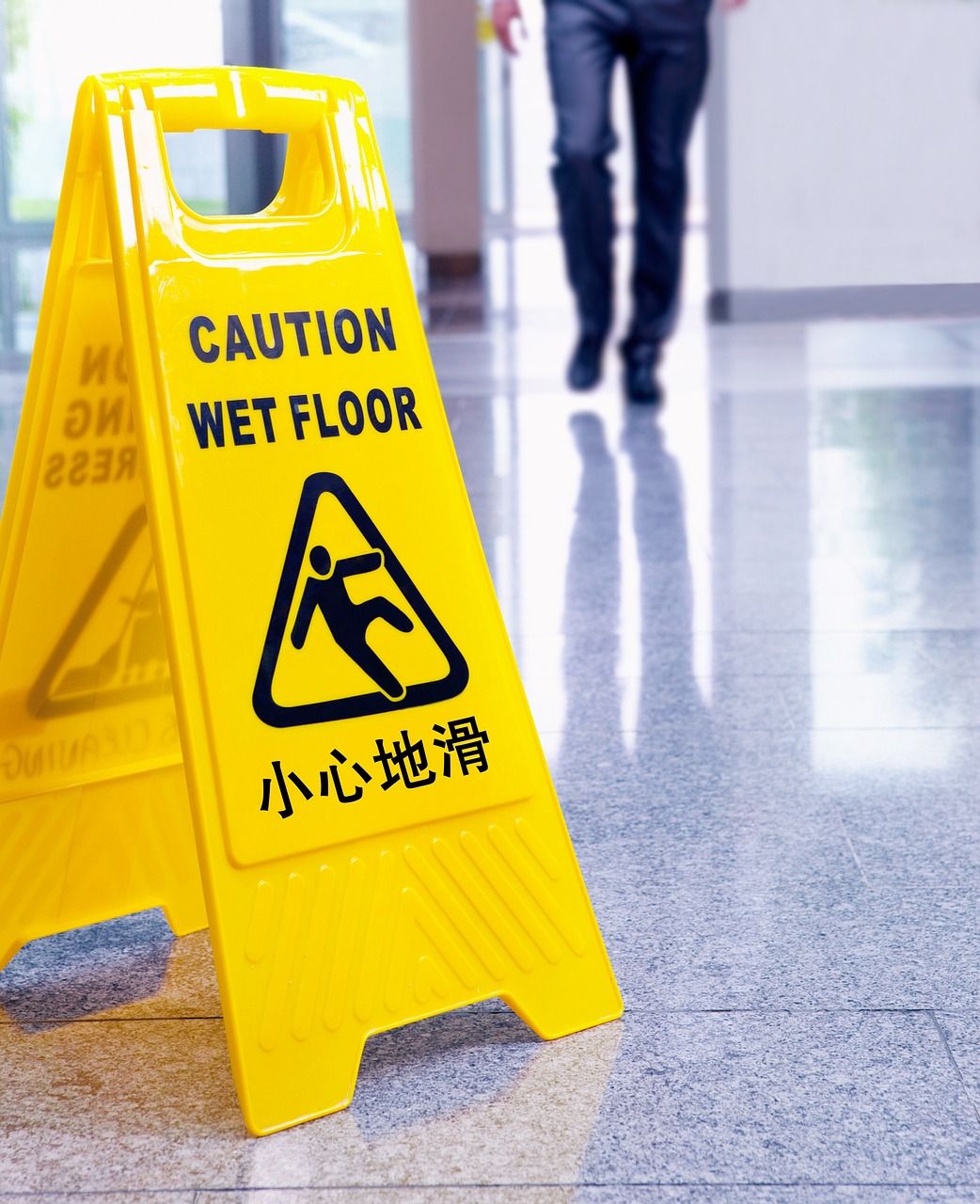 wet floor safety hazard sign on tile floor